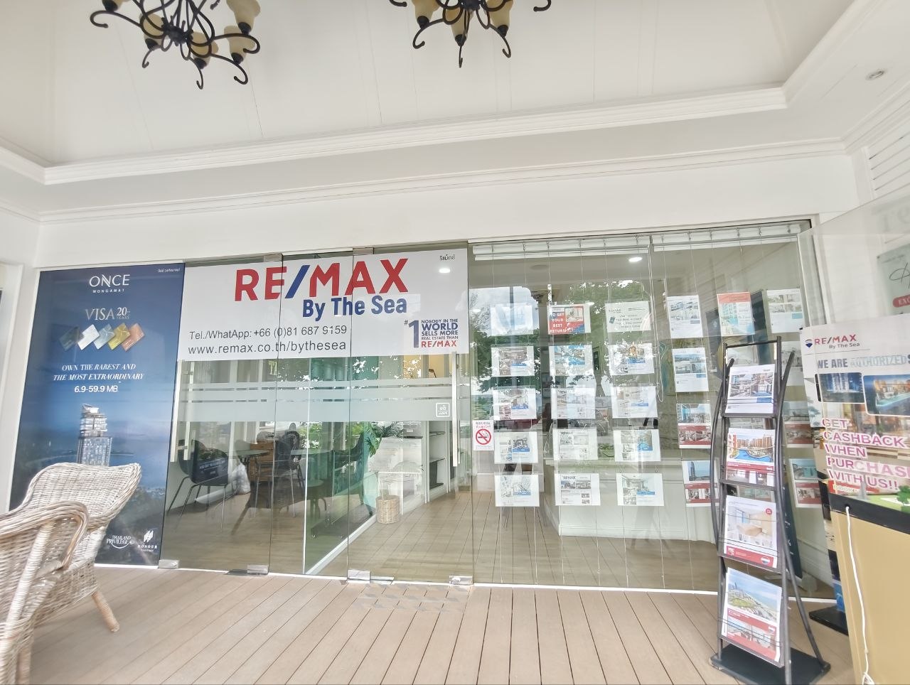 RE/MAX By The Sea glass-front office signage and property listings